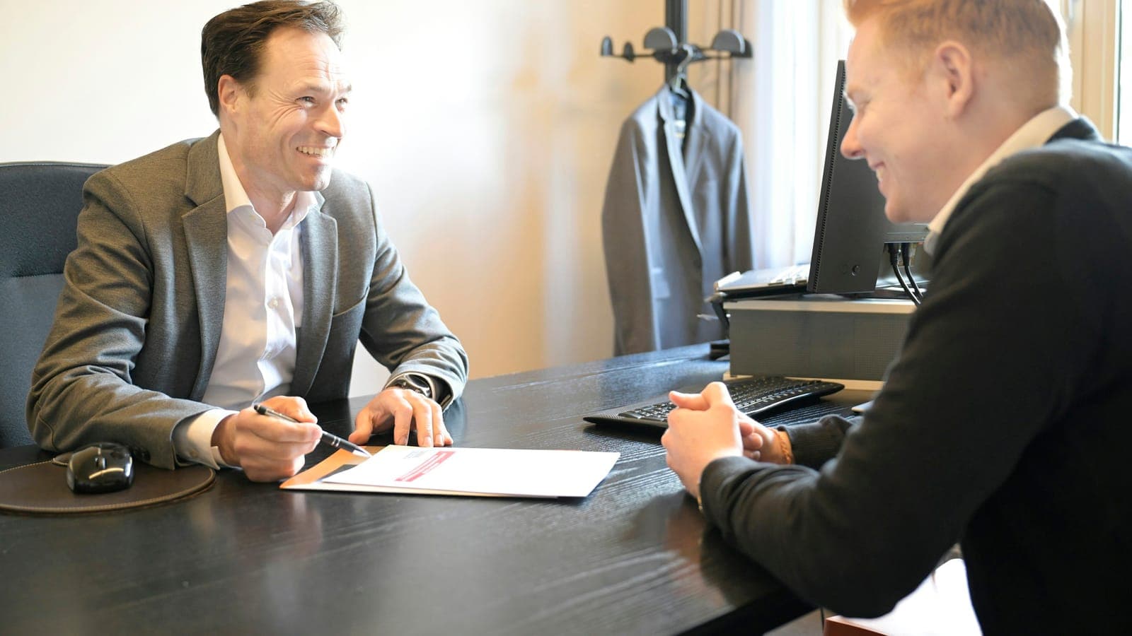 Two attorneys reviewing case documents at an office desk
