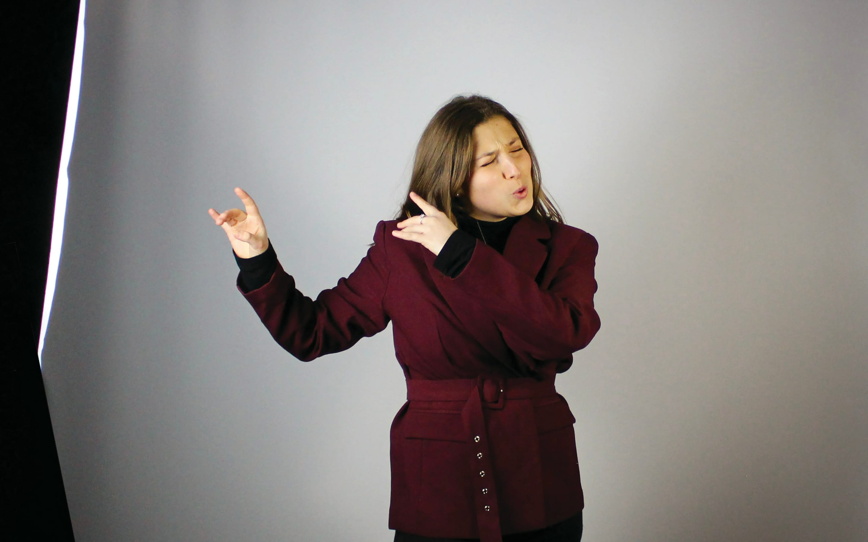 Sign language interpreter signing in a studio