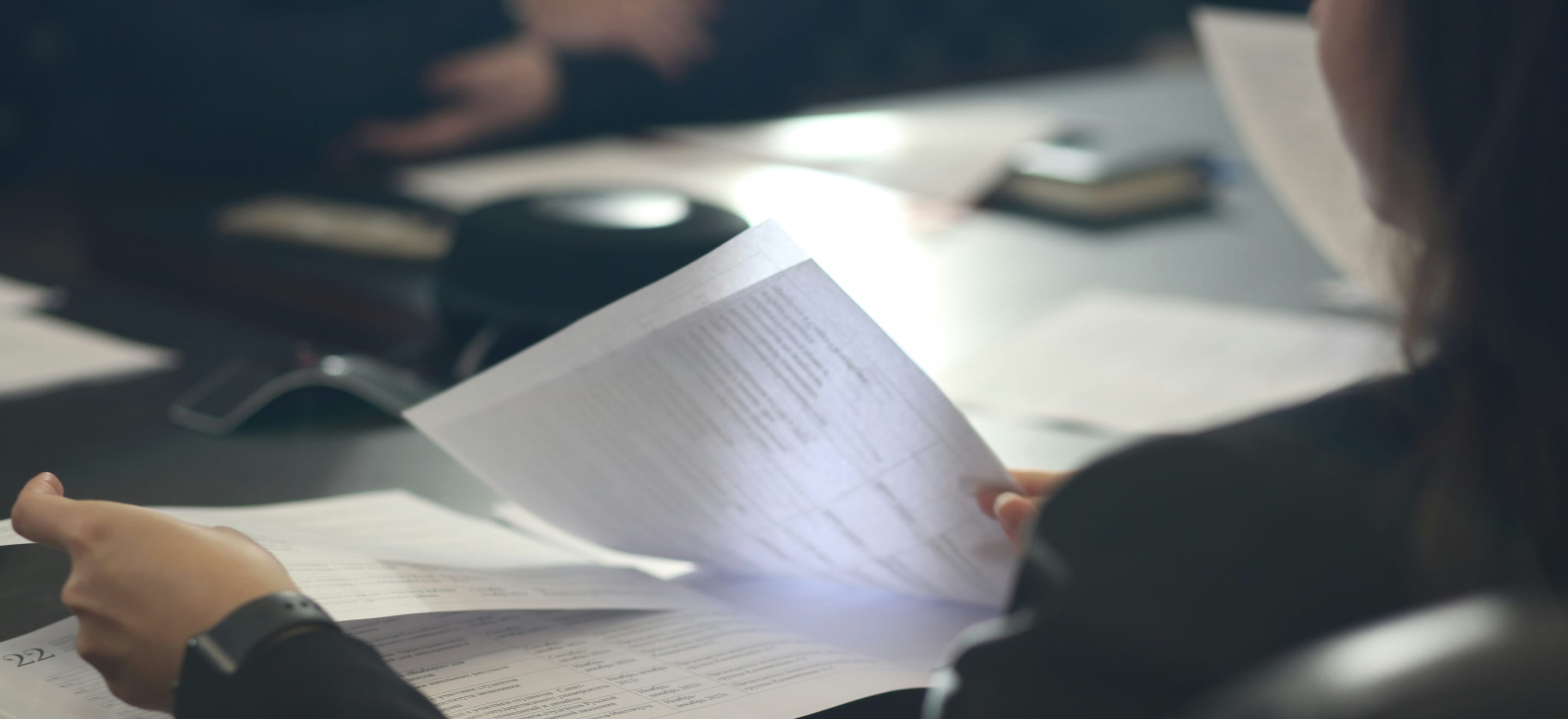 Linguist reviewing a printed document at her desk