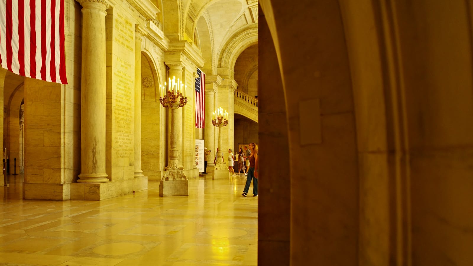 Ornate civic hall with columns, arches, and chandeliers
