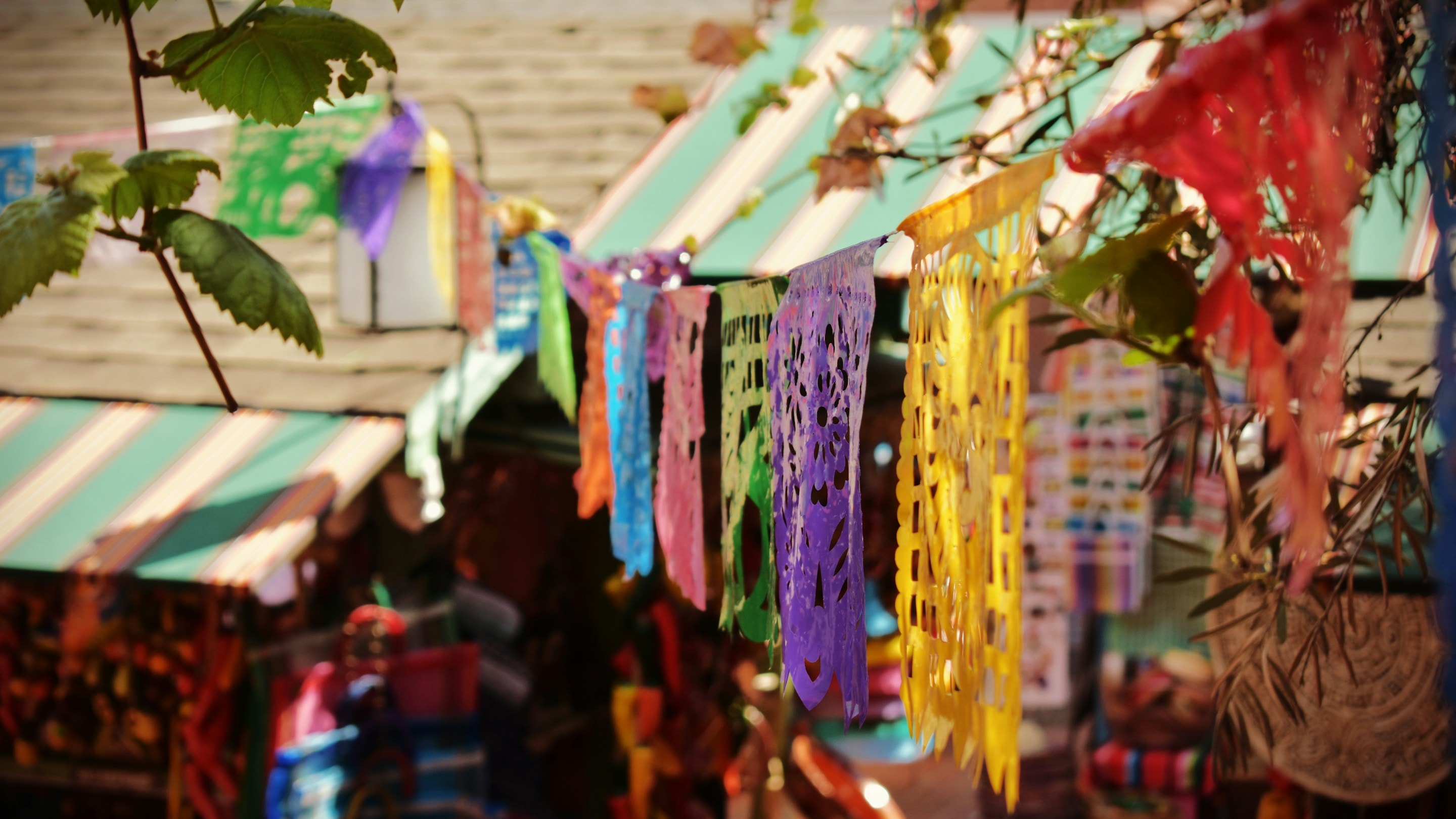 Colorful papel picado banners hanging over market stalls on Olvera Street in Los Angeles